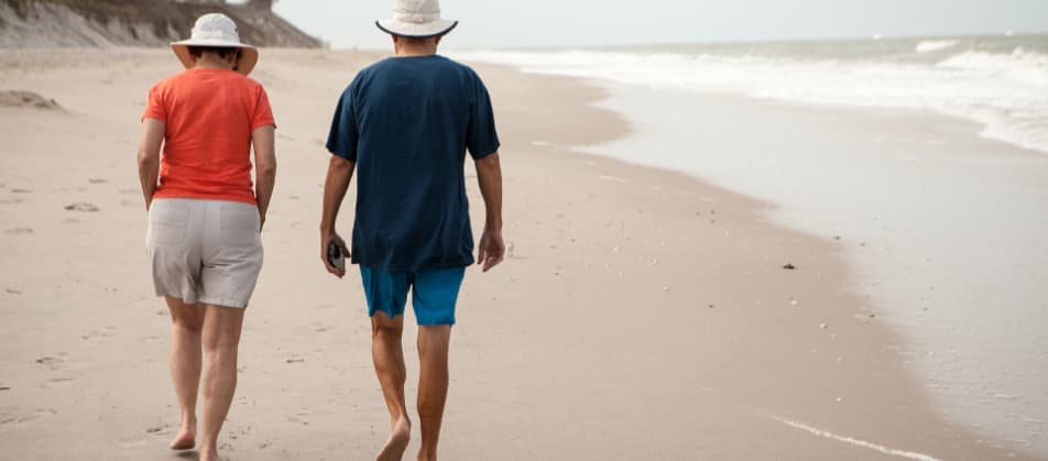 Ehepaar genießt neue Schuldenfreiheit bei einem Strandspaziergang - Privatinsolvenz Wesel