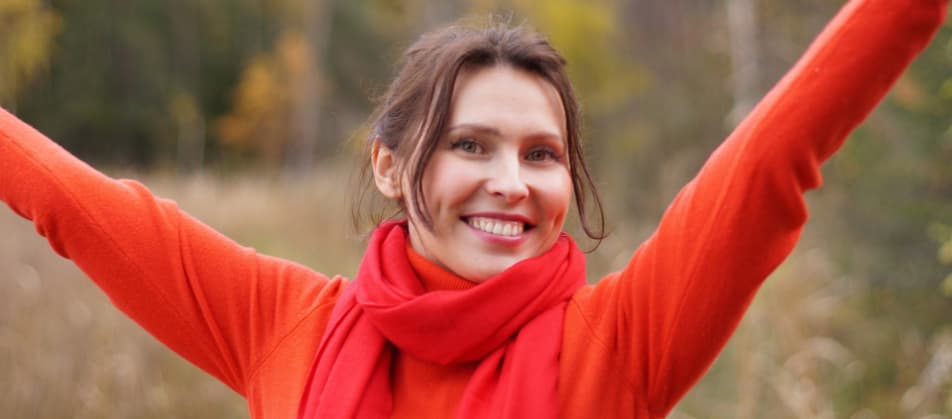 Junge Frau reckt ihre Arme nach oben und lächelt weil sie von Überschuldung befreit ist, dank schneller Hilfe durch Berater Privatinsolvenz Nürtingen